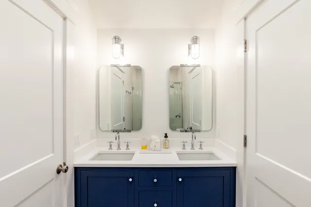 a bathroom with double vanity sinks and a mirror