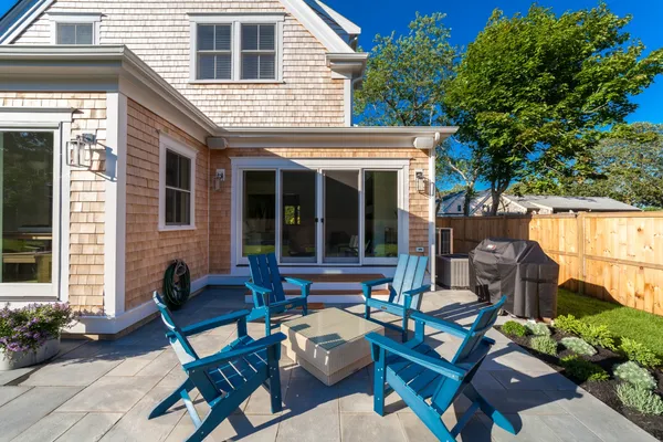 a view of a patio with couple of couch in front of house