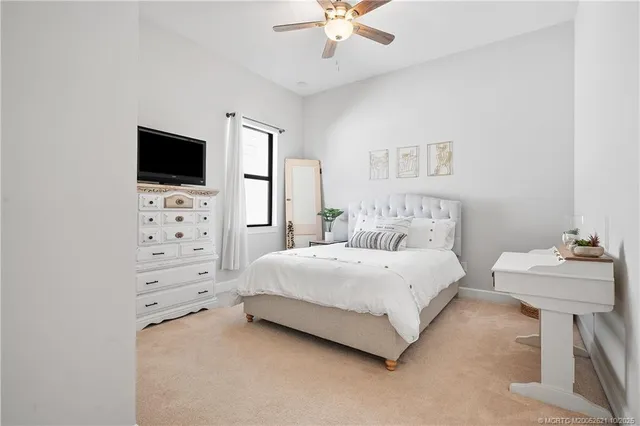 a spacious bedroom with a bed and a flat screen tv