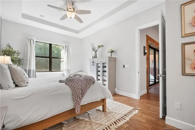 a bedroom with a large bed a chandelier and windows