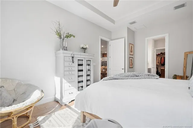 a view of a bedroom with a bed and wooden floor