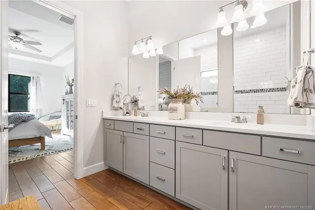 a bathroom with a double vanity sink mirror and next to a window