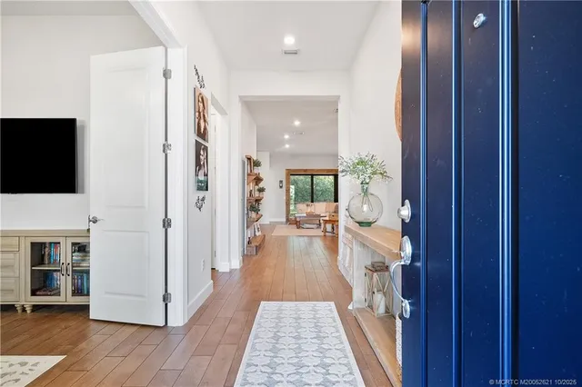 a kitchen with stainless steel appliances a dining table chairs refrigerator and microwave