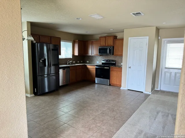 a kitchen with stainless steel appliances granite countertop a refrigerator and a stove