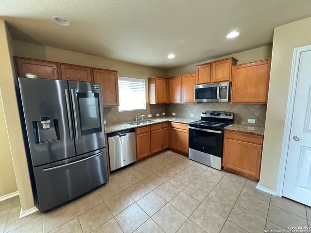 a kitchen with stainless steel appliances granite countertop a refrigerator sink and microwave