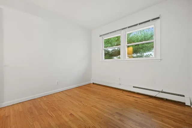 an empty room with wooden floor and a window