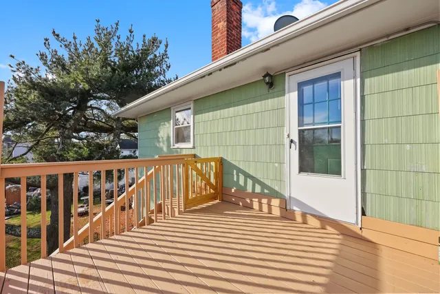 a view of a balcony with wooden floor and fence