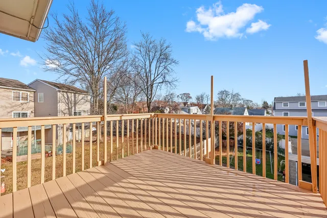 a view of a balcony with wooden floor and fence