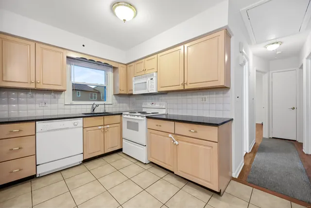 a kitchen with granite countertop cabinets stainless steel appliances a sink and a window