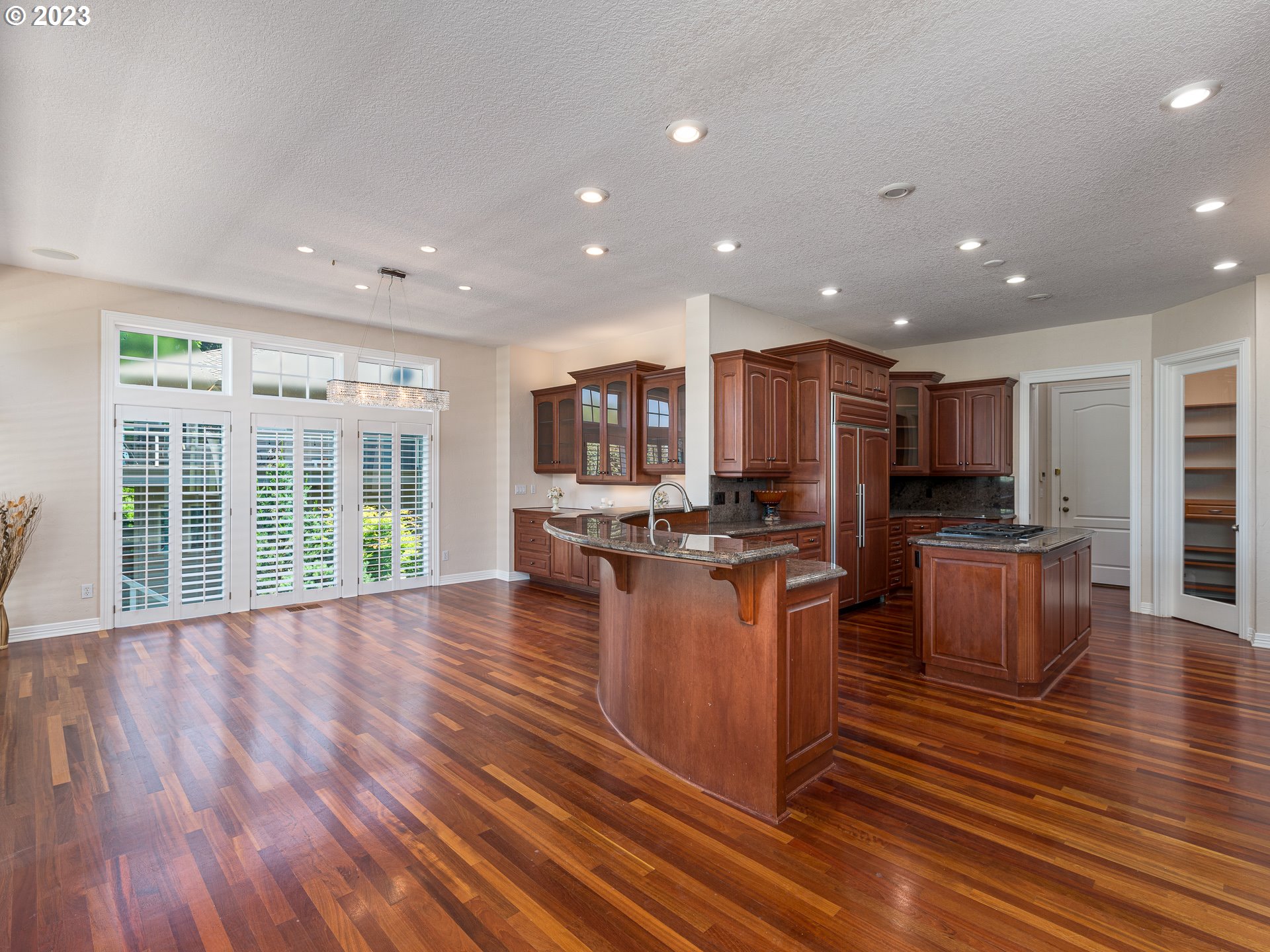 565 Southeast 46th Drive Gresham, OR 97080 - Photo 11 of 48 a open kitchen with stainless steel appliances granite countertop a refrigerator a stove top oven a dining table and chairs with wooden floor