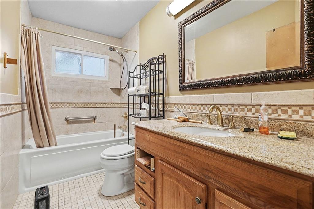 91 Berlin Street Tallapoosa, GA 30176 - Photo 19 of 25 a bathroom with a granite countertop sink a toilet and a mirror
