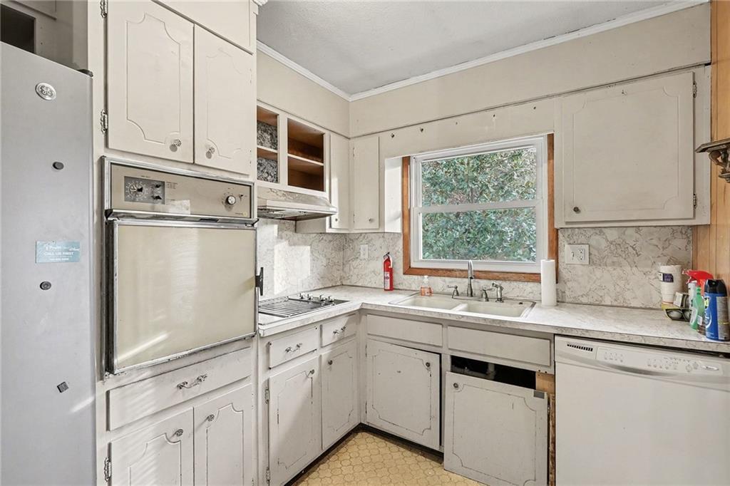 91 Berlin Street Tallapoosa, GA 30176 - Photo 7 of 25 a kitchen with granite countertop white cabinets white appliances a sink and a window
