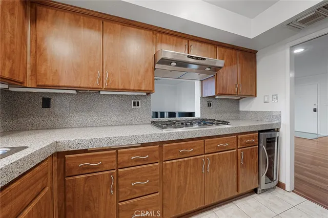 a kitchen with kitchen island granite countertop a sink and a stove