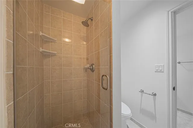 an empty room with wooden floor closet and windows