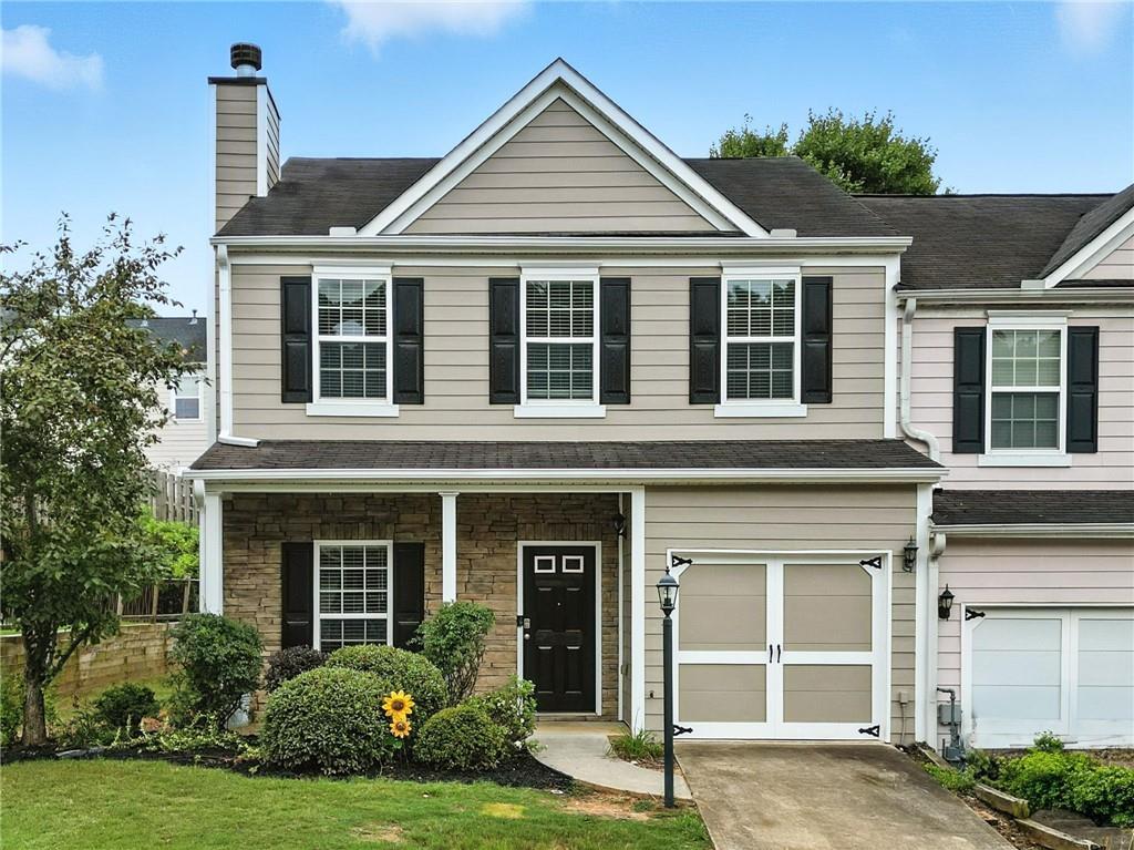 121 Spring Way Square Canton, GA 30114 - Photo 1 of 1 a front view of a house with a yard and garage