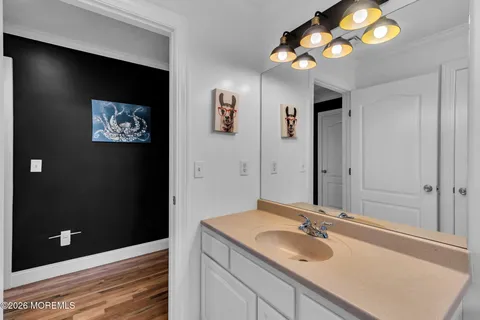 a view of a white house with a big yard and potted plants and large trees