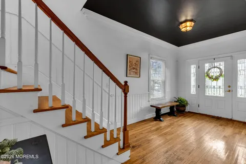 a view of a hallway with wooden floor and closet area