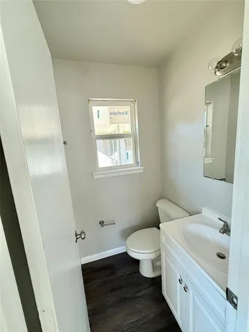 a bathroom with a granite countertop toilet and a sink