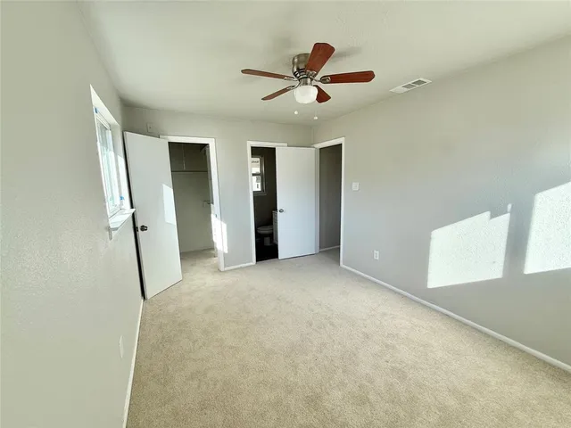 a view of a livingroom with a ceiling fan & entryway