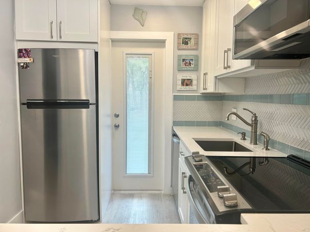 a kitchen with granite countertop a sink and a stove