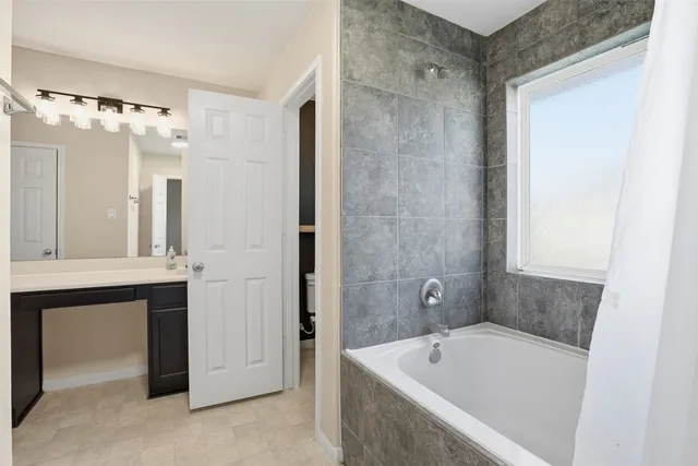 a bathroom with a tub sink and mirror