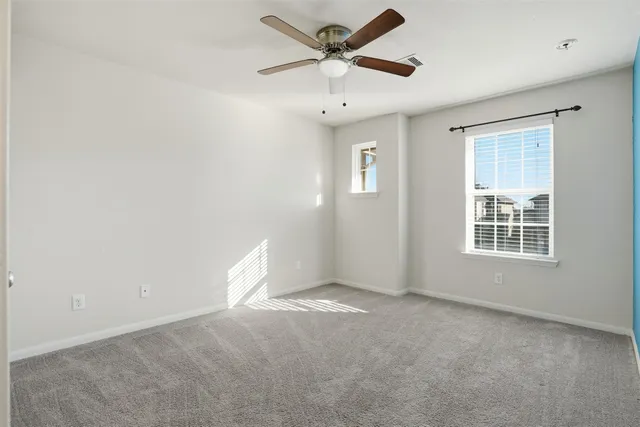 an empty room with closet and a chandelier fan