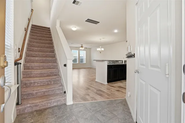 a view of a hallway with stairs and a front door