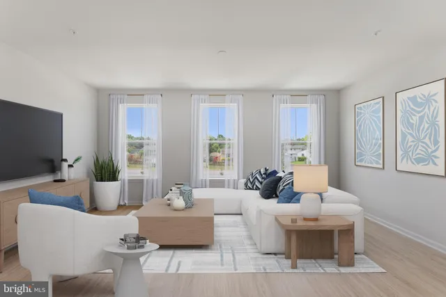 a living room with furniture a large window and a flat screen tv