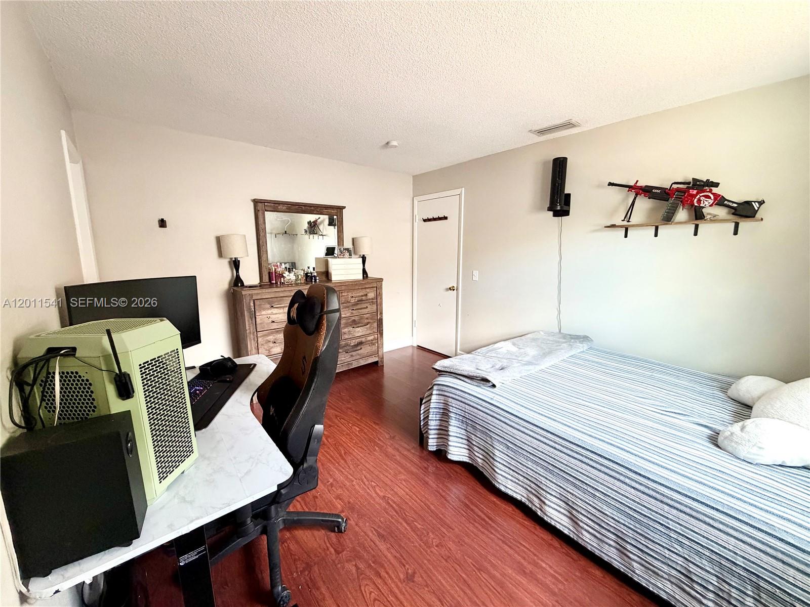 143 Valley Circle Brandon, FL 33510 - Photo 12 of 21 a bedroom with a bed and wooden floor