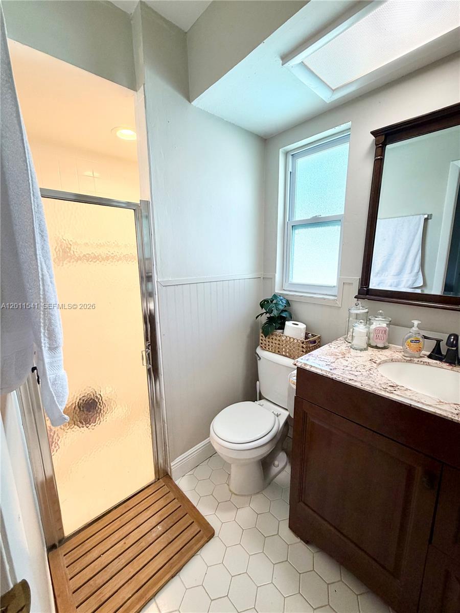 143 Valley Circle Brandon, FL 33510 - Photo 15 of 21 a bathroom with a toilet a sink a mirror a window and vanity