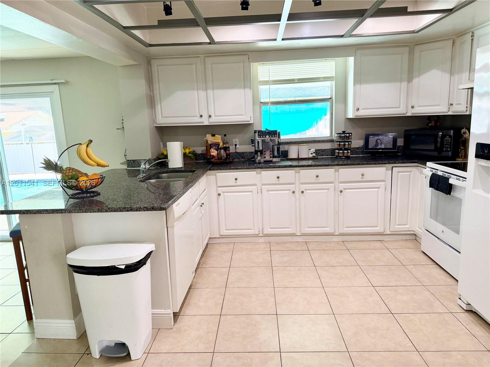 143 Valley Circle Brandon, FL 33510 - Photo 16 of 21 a kitchen with a sink a stove a microwave and cabinets