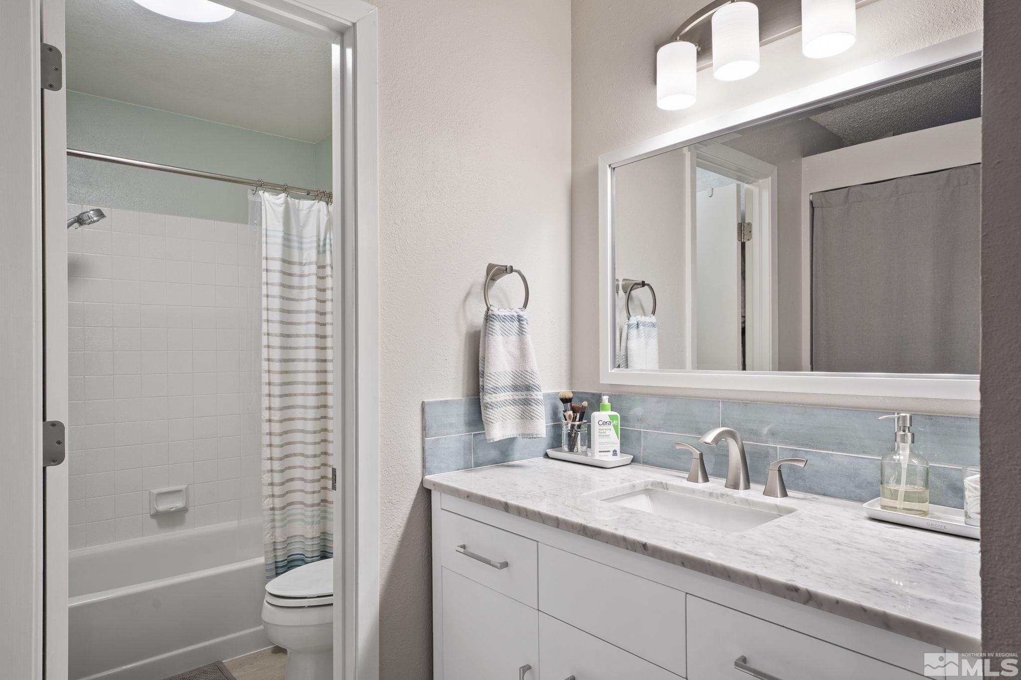 4391 Loreto Lane Reno, NV 89502 - Photo 22 of 39 a bathroom with a granite countertop sink a toilet and a bathtub