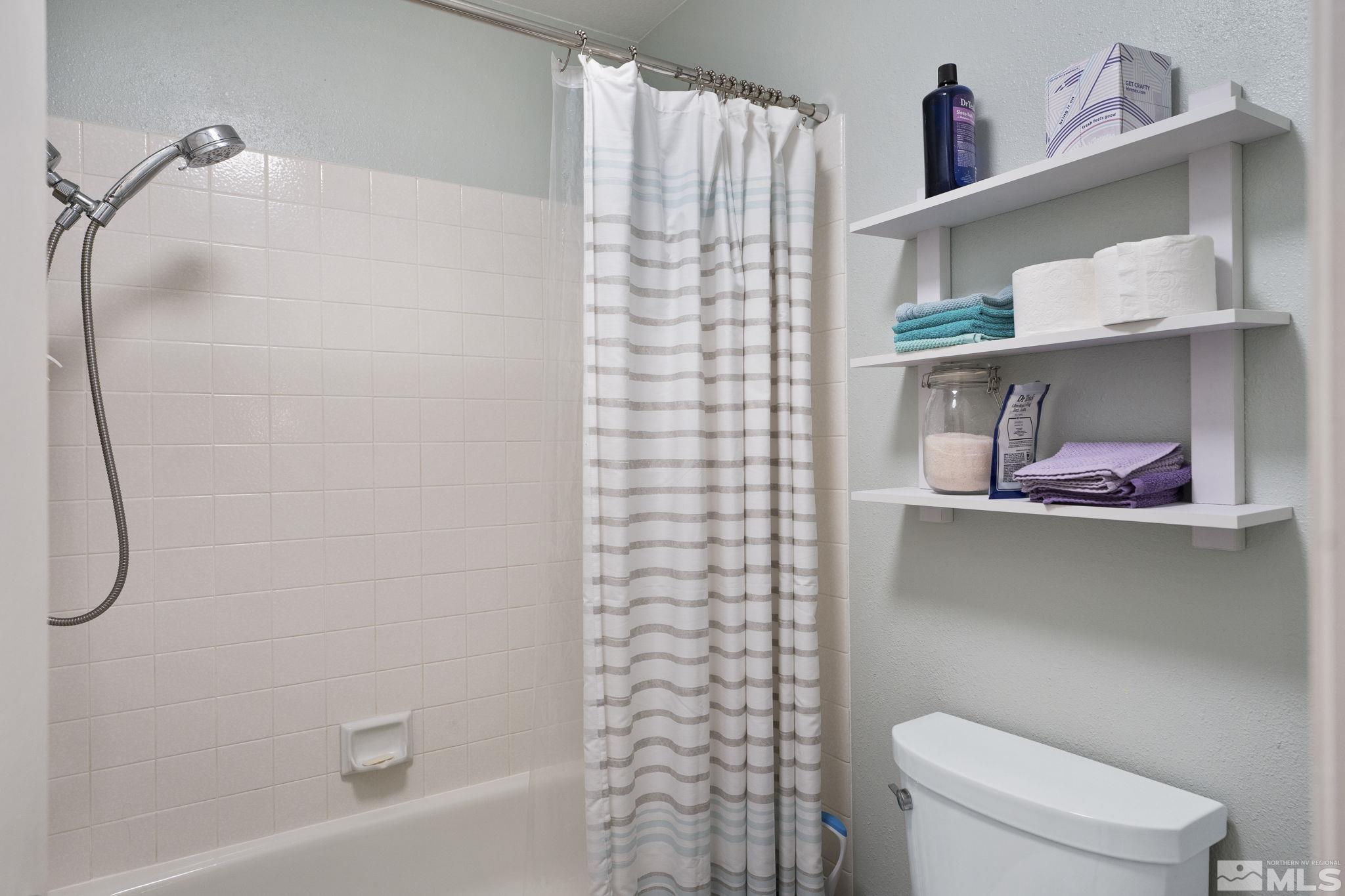 4391 Loreto Lane Reno, NV 89502 - Photo 23 of 39 a bathroom with a shower curtain and a toilet