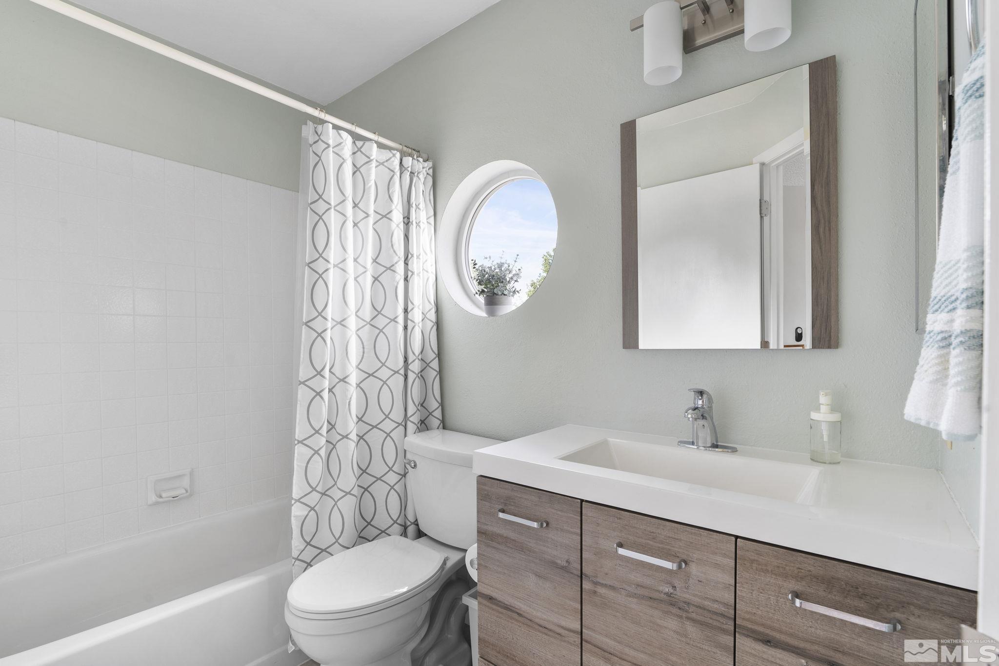4391 Loreto Lane Reno, NV 89502 - Photo 27 of 39 a bathroom with a toilet a sink a mirror and bathtub