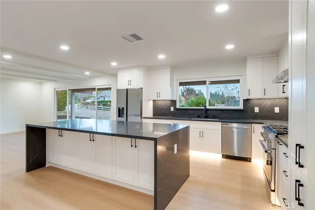 a kitchen with stainless steel appliances granite countertop a sink and cabinets