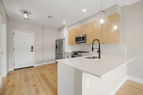 a kitchen with a sink a counter top space cabinets and stainless steel appliances