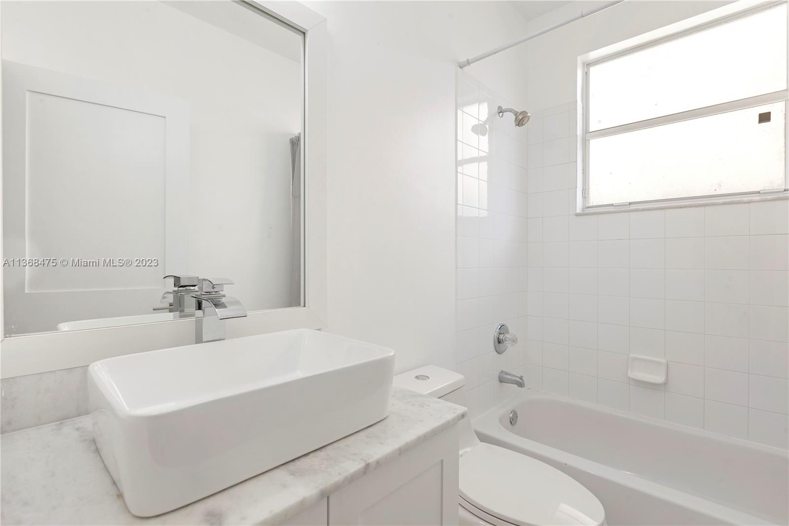 24547 Southwest 109th Avenue Homestead, FL 33032 - Photo 16 of 20 a bathroom with a bathtub a sink a toilet and a shower