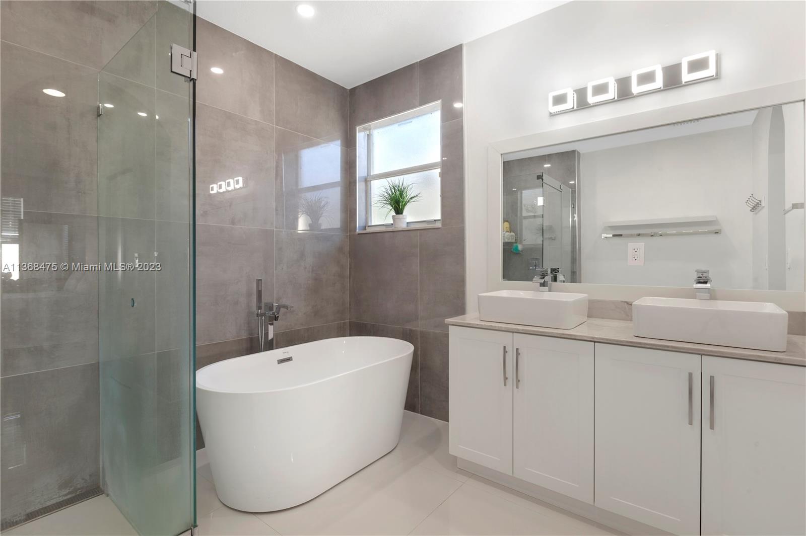 24547 Southwest 109th Avenue Homestead, FL 33032 - Photo 18 of 20 a bathroom with a toilet a sink a mirror a bathtub and vanity