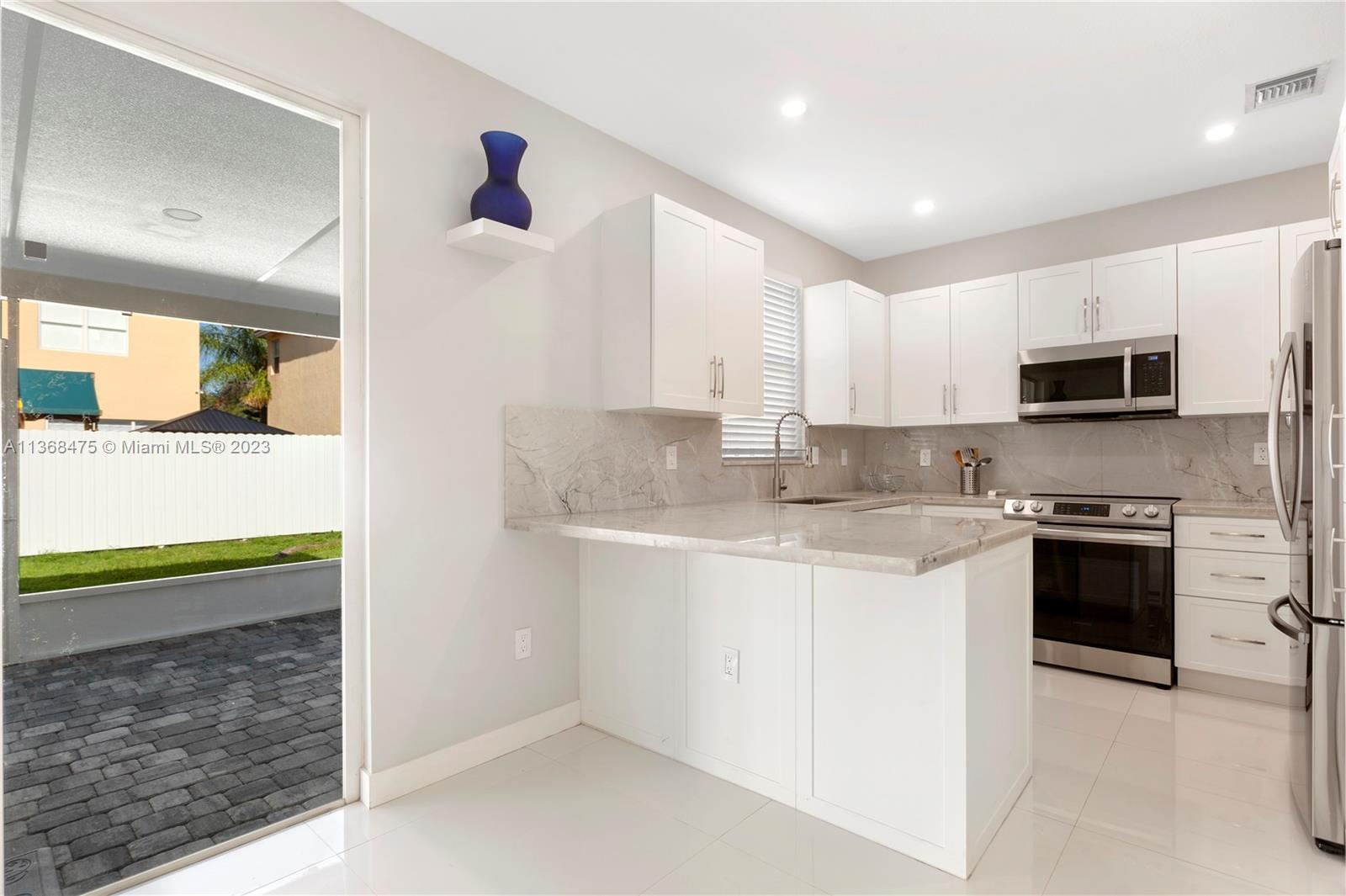24547 Southwest 109th Avenue Homestead, FL 33032 - Photo 6 of 20 a kitchen with stainless steel appliances granite countertop a stove and a sink