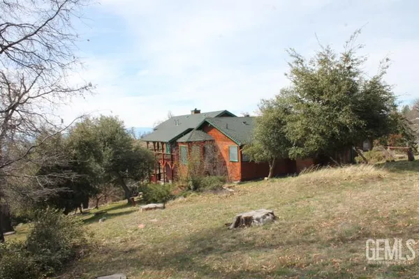 a view of a house with a deck and a yard