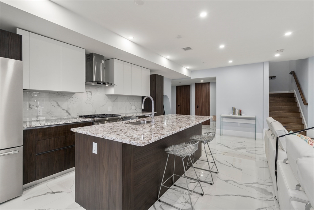 32 Pearl Street, Unit 4 Boston, MA 02125 - Photo 11 of 35 a kitchen with stainless steel appliances granite countertop a sink stove and cabinets