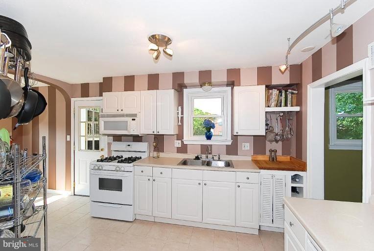 704 Charing Cross Road Baltimore, MD 21229 - Photo 9 of 20 a kitchen with white cabinets and appliances