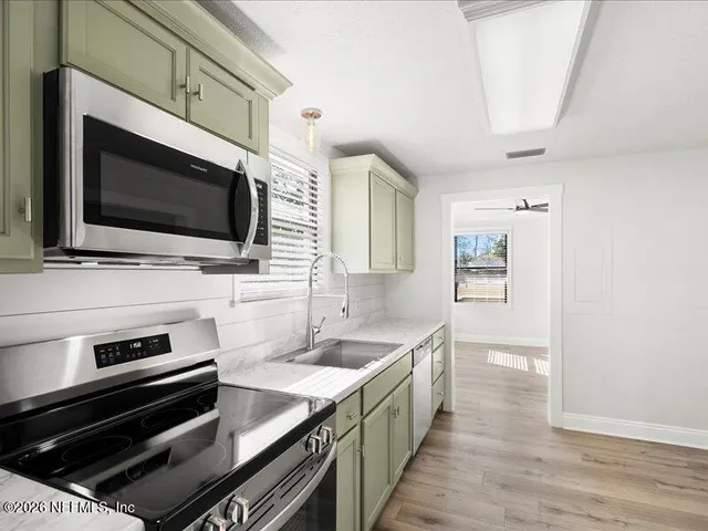 a kitchen with a sink stove and microwave