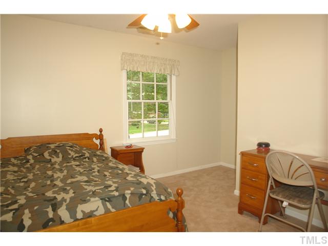 8508 Seagate Drive Raleigh, NC 27615 - Photo 18 of 25 a bedroom with a bed and a chair