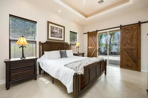 a bed sitting in a spacious bedroom next to a window