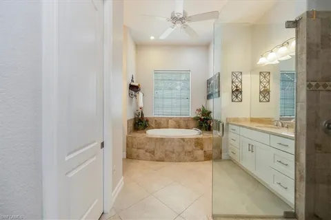 a spacious bathroom with a tub sink shower and mirror