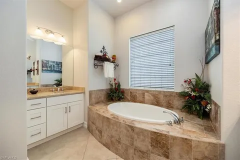 a bathroom with a granite countertop tub a sink and mirror