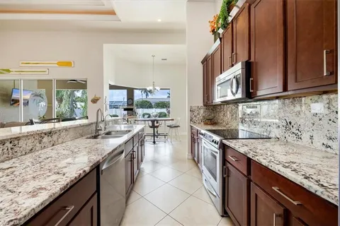 a kitchen with granite countertop a sink a counter top space and cabinets