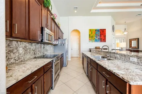 a kitchen with stainless steel appliances granite countertop a sink stove and cabinets