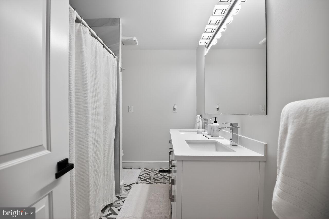 4304 Bridgeboro Road Moorestown, NJ 08057 - Photo 25 of 40 a bathroom with a sink a mirror and a shower